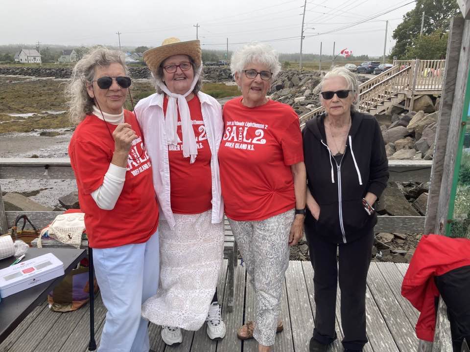 4 women standing on a deck over Westport harbour